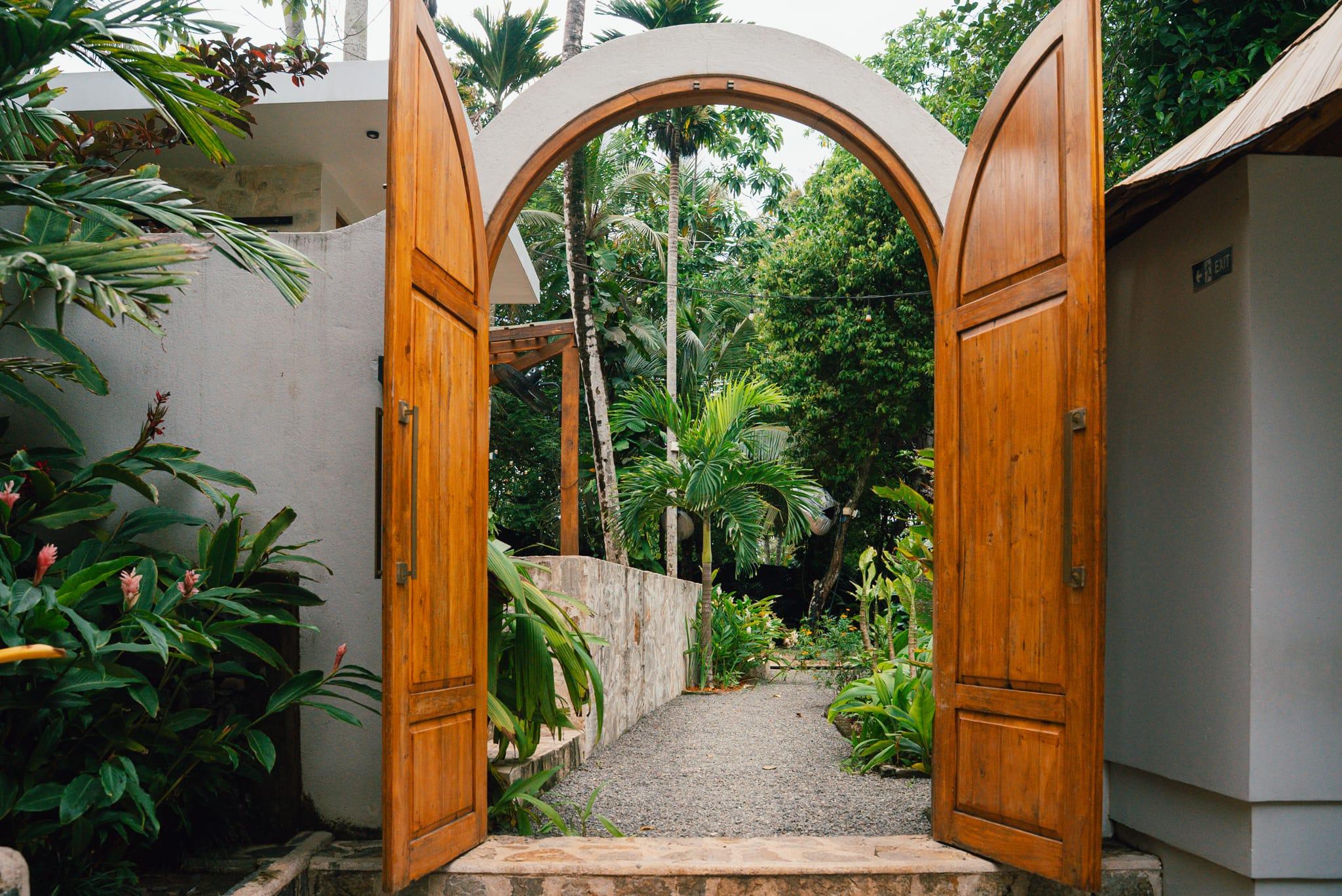 Hidden's arched wooden doors opening onto the garden path