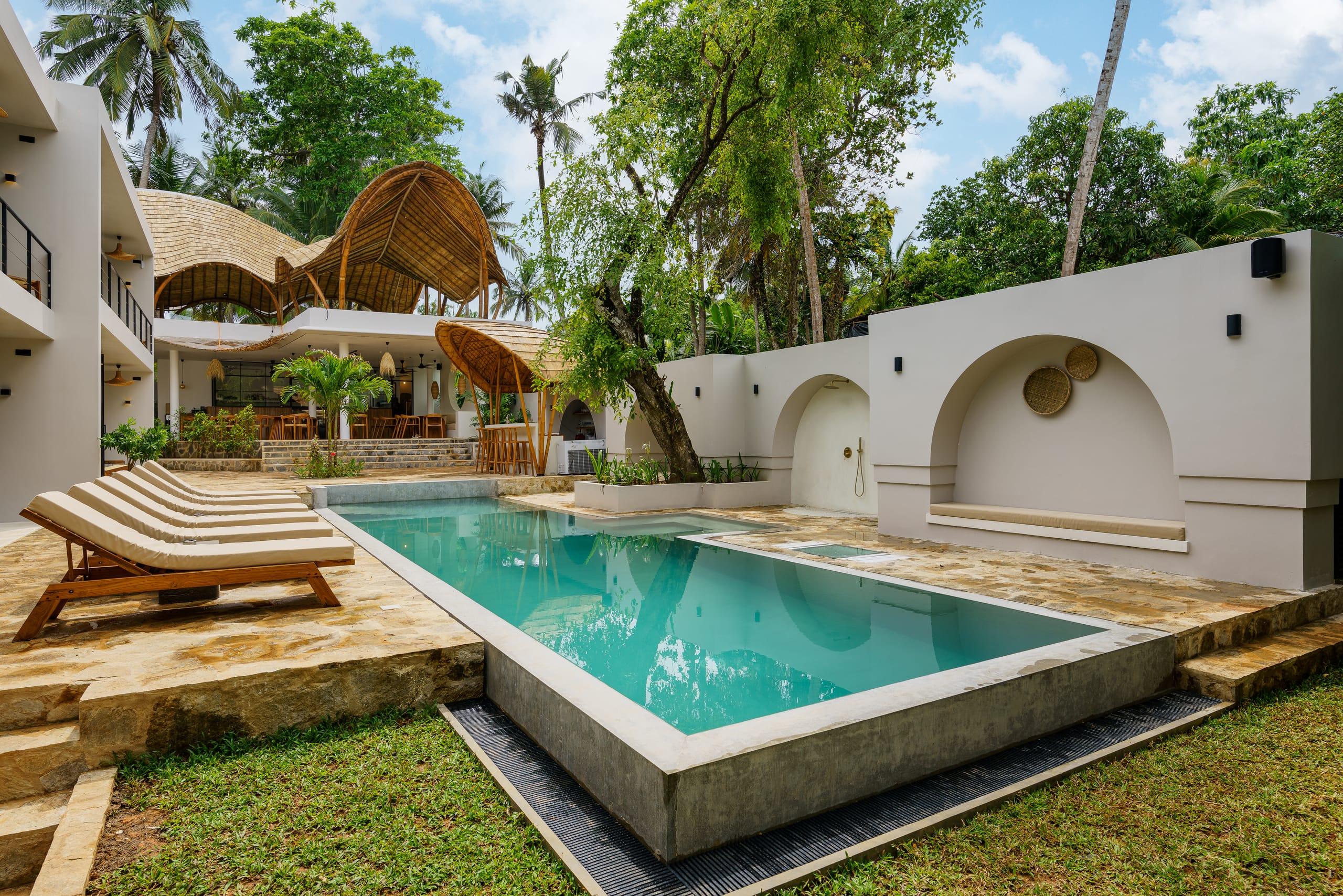 Terra Resort's pool and white arches beneath the wavy shala roof