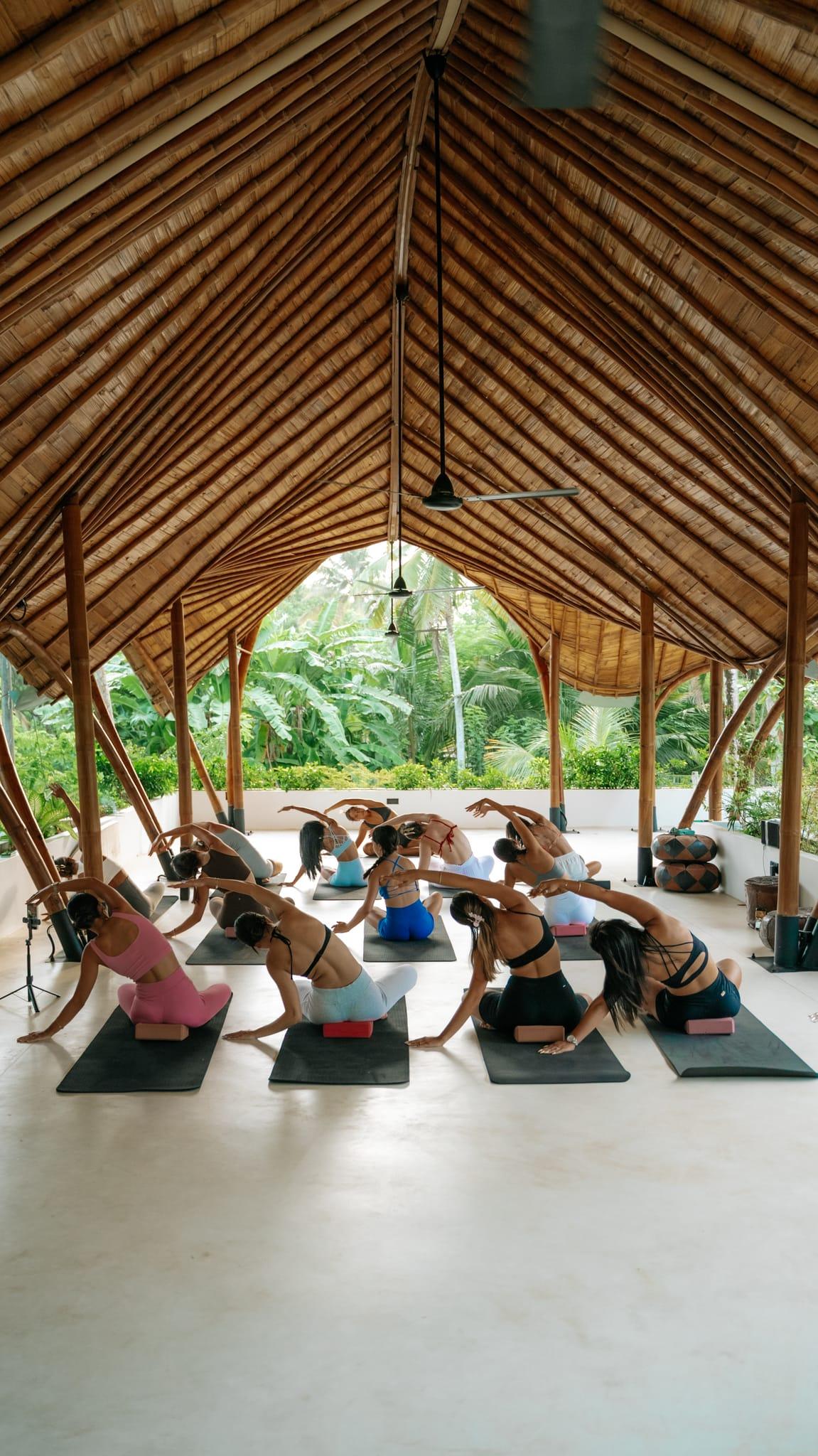 The class mid-practice under the bamboo vault of the shala